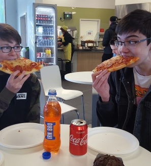 Some men eating pizza
